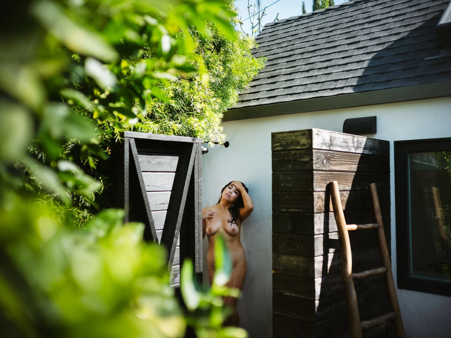 Client at the outdoor shower of the Boudoir Bungalow surrounded by greenery