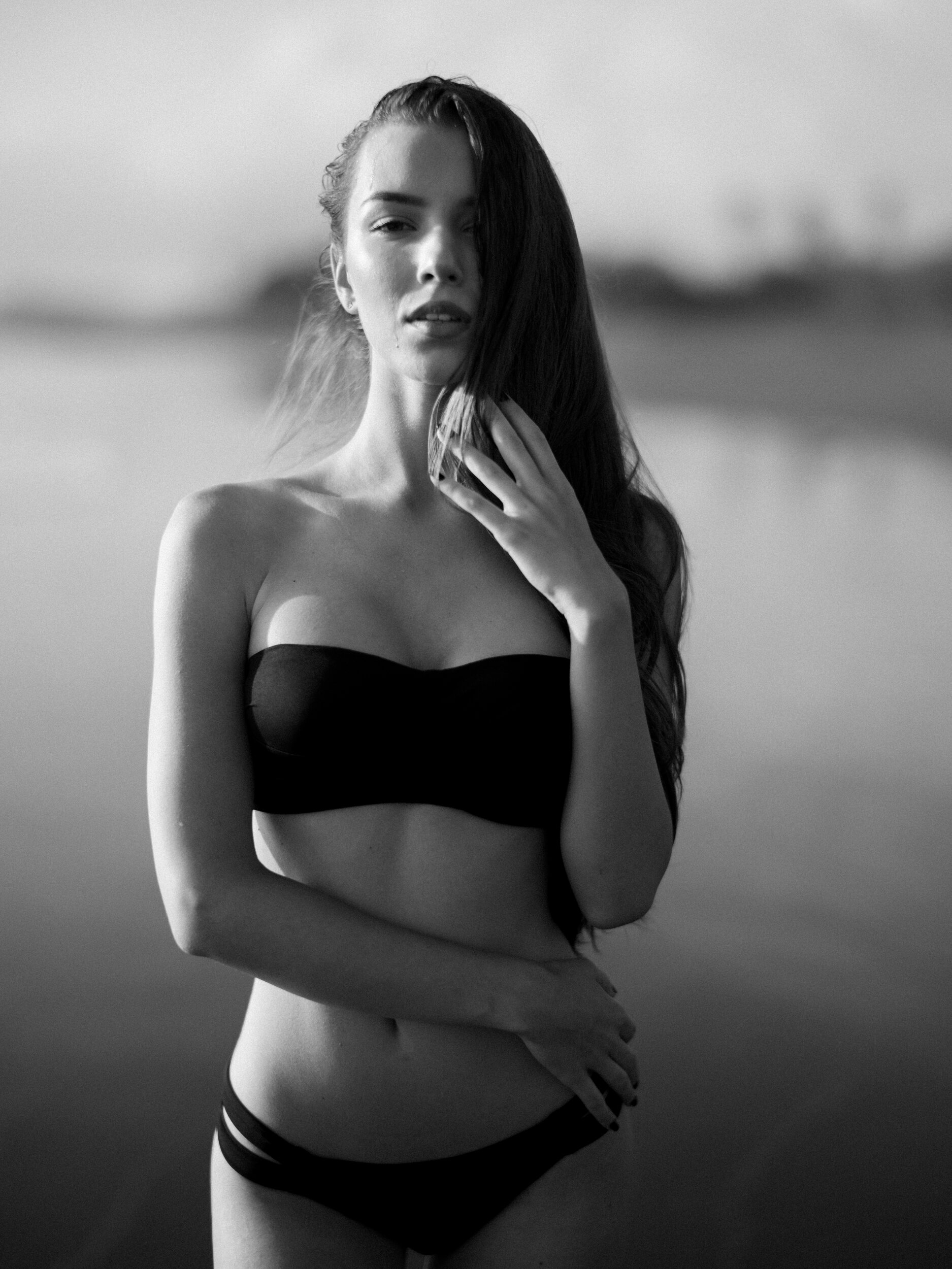 Black-and-white lakeside portrait in a black strapless top